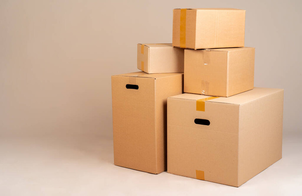 Pile of brown moxing boxes on grey background - Foto, imagen