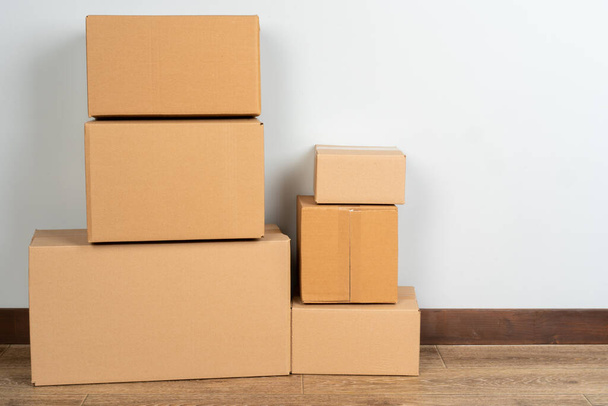 Group of brown carton boxes on wooden floor - Фото, зображення