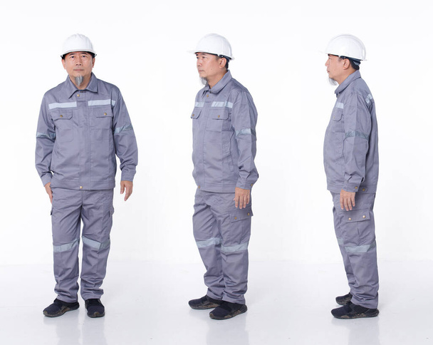 Full length portrait 50s 60s Asian elderly Man in Gray uniform hardhat as electric engineer, isolated. Electrical Technician male stand, turn many angle view front side rear, white background studio - Photo, Image