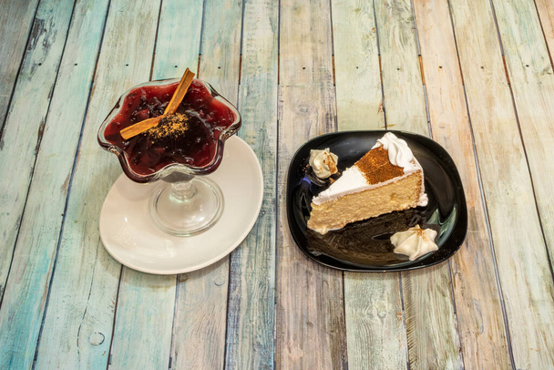 Latin American desserts, purple mazamorra and tres leches cake on wooden table - Foto, Imagem