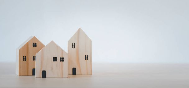 木製のテーブルのモデルからミニ木製の家のモデルは、計画は、不動産を購入し、プロパティを購入し、最良の選択を計画。家で仕事をして家のコンセプトに. - 写真・画像