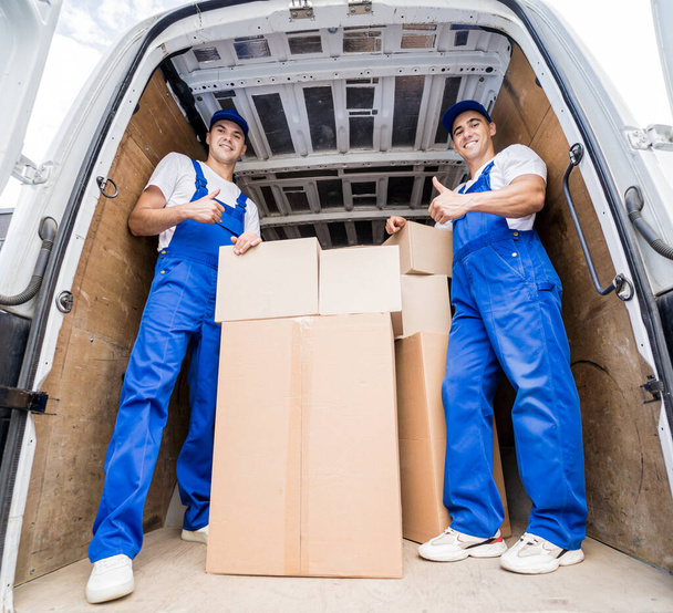 Two removal company workers unloading boxes from minibus - Zdjęcie, obraz