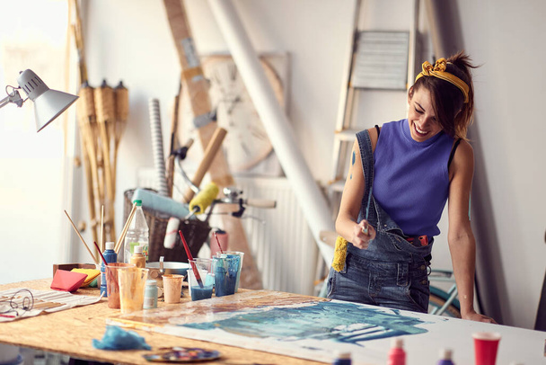 Woman painter drawing on a canvas in art studio. - Foto, Bild