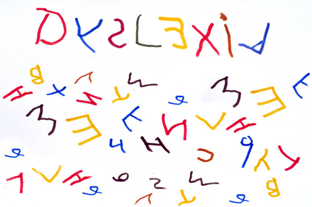 Concepto de dislexia con una palabra y letras del alfabeto escritas en diferentes colores sobre un fondo blanco  - Foto, imagen