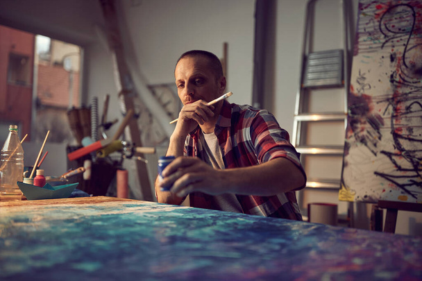 Man painter at workspace. Artist working on new paint.  - Fotó, kép