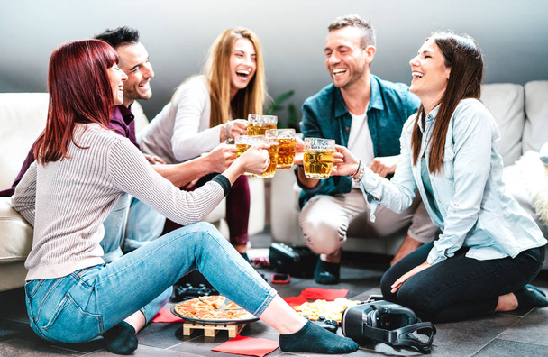 Молодые друзья пьют пиво на домашней вечеринке после уроков в колледже - Концепция дружбы в стиле жизни со студентами, которые наслаждаются временем вместе, наслаждаясь едой в общей квартире - Яркий фильтр - Фото, изображение