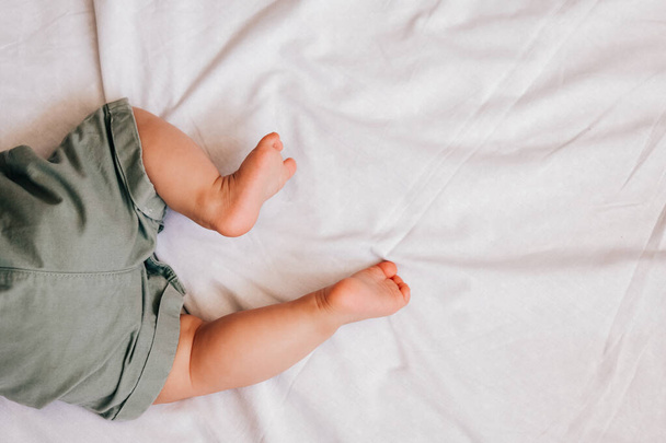 cute 6 month baby feet on white sheet - Fotografie, Obrázek