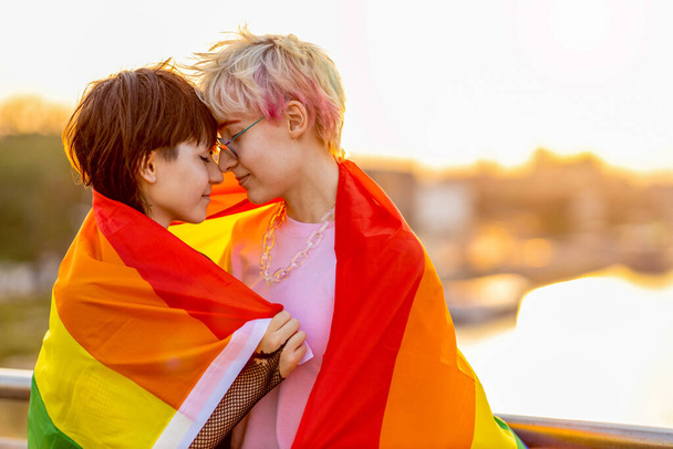 Portret van een vloeiend echtpaar met een regenboogvlag - Foto, afbeelding