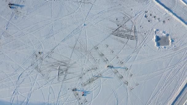 ベルジュ・デ・クオーツヴェントの凍る川を覆う白い雪の中で、あらゆる種類のトラックをまっすぐ下って撮影された高空のドローンビュー - 映像、動画