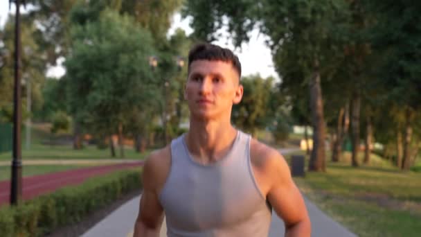 νεαρός αθλητικός άνδρας που τρέχει το πρωί υπαίθρια αντιμετωπίζει την ανατολή, προπόνηση - Πλάνα, βίντεο