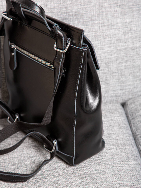 Black backpack bag with straps with zippers. bag for things, accessories and textbooks is in the interior of apartment. - 写真・画像