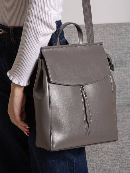 Grey bag backpack with straps with zippers. bag for things, accessories and textbooks is in the interior of apartment. - Фото, изображение