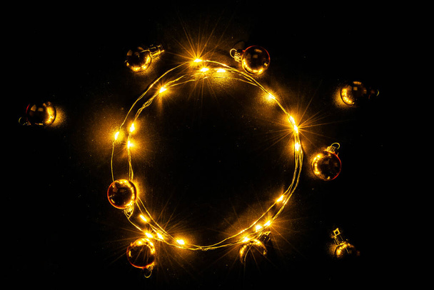 Рождественские огни границы. Золотая световая гирлянда, золотая лампочка на черном фоне для украшения новогодней вечеринки. Светящиеся огни на Рождество - Фото, изображение