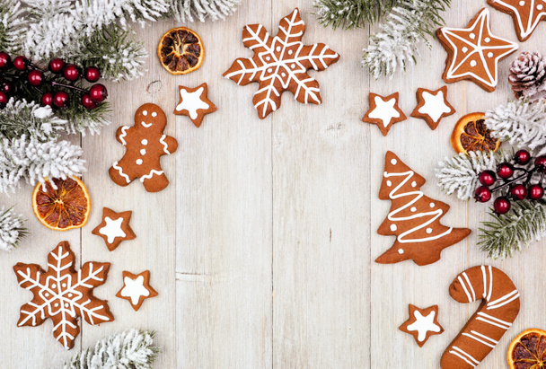 Cadre de Noël de biscuits au pain d'épice et branches d'arbre givrées. Vue de dessus sur un fond rustique en bois gris avec espace de copie. - Photo, image