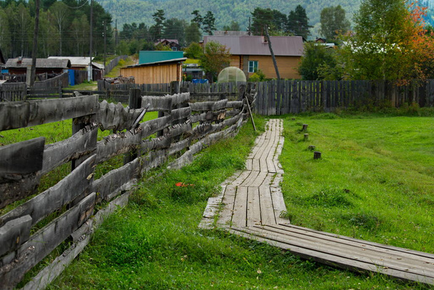 A Rússia. Transbaikalia, região de Chita. Uma cerca de madeira feita de tábuas e postes, que encerram pastagens e propriedades na aldeia de Krasny Priisk. - Foto, Imagem