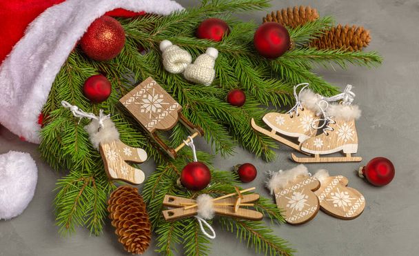 サンタクロースの帽子に横たわっているクリスマスツリーの枝に木製のクリスマスの装飾やクリスマス飾り. - 写真・画像