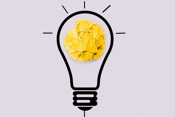 Ideas de pensamiento creativo y concepto de innovación. Pelota de chatarra de papel color amarillo con símbolo de bombilla sobre fondo blanco - Foto, Imagen