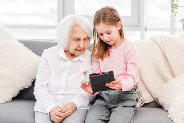 Grandmother with grandaughter using tablet - Photo, image