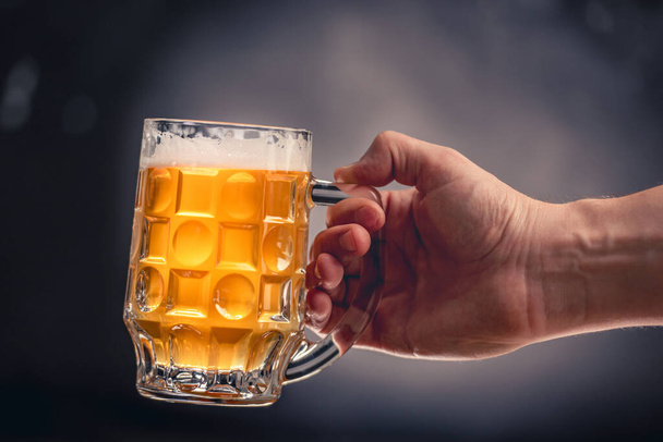 Hand holding beer mug - Фото, изображение