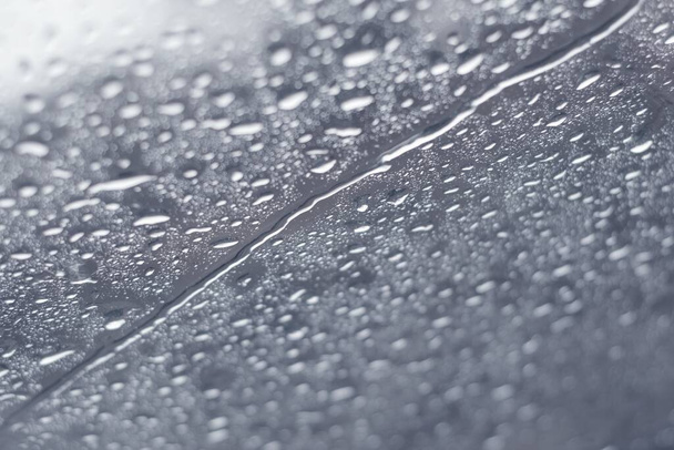 Krople deszczu kapiące przez okno w mroźny zimowy dzień. Zbliżenie, tekstura tła. - Zdjęcie, obraz