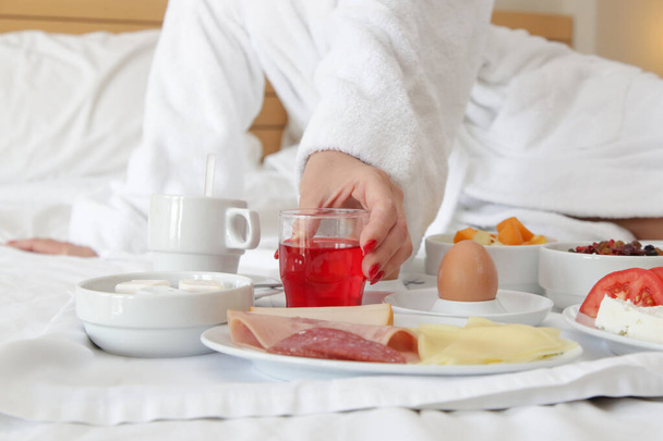Woman having breakfast in bed. - Photo, Image