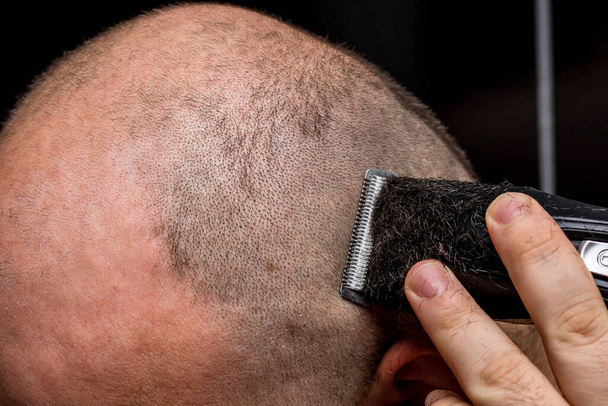 Mężczyzna golenie lub przycinanie włosów za pomocą strzyżenia - Zdjęcie, obraz