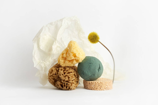 Natural sponges, wrapping paper and flower on white.Creative concept photography - Foto, immagini