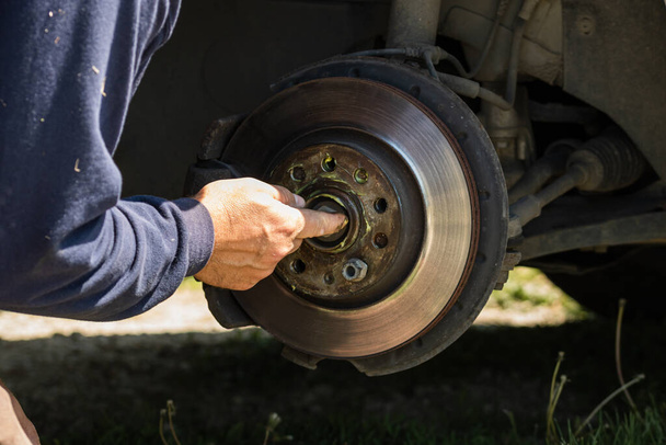 Mechanic cleaning and fixing the brake system of a car in Romania, Targoviste, 2021 - Zdjęcie, obraz