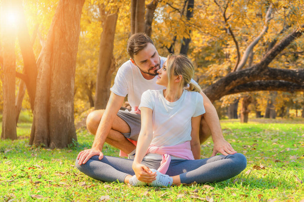 cuacasian couple in sportswear having stretching together before workout outdoors in park in autumn. healthy and wellbeing lifestyle activity of athletic people - Foto, Imagem