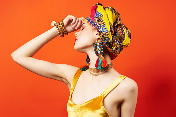 красивая женщина этническая многоцветный платок макияж гламурный красный фон - Фото, изображение