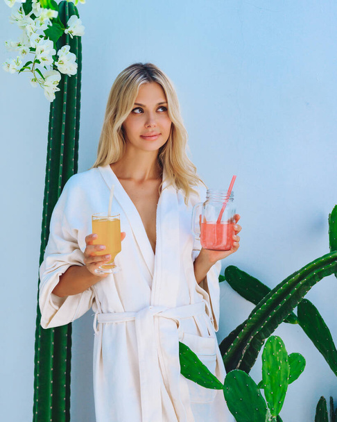 A blonde in a white cholat with a drink and a straw made from natural products. Zero waste concep - Foto, imagen