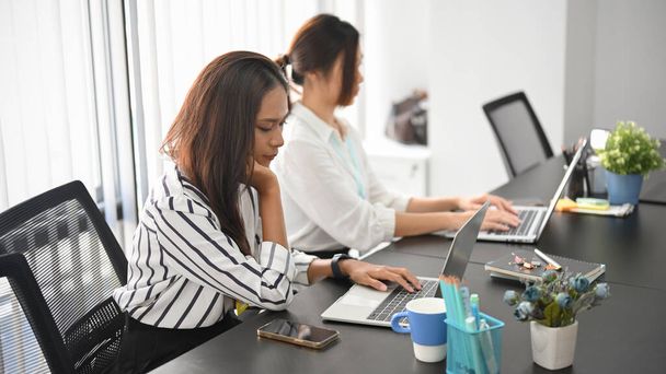 Бизнесмены, работающие за ноутбуком в современном офисе, бизнес-команда, работающая в конференц-зале - Фото, изображение