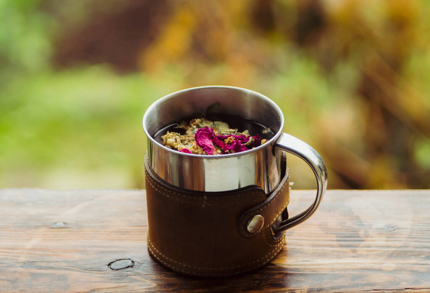 Touristic mug with herbal tea on the rustic background. Selective focus. - Foto, immagini