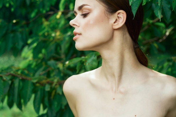 smiling woman skin care bare shoulders green leaves nature cropped view - 写真・画像