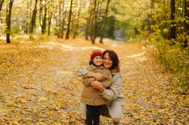 Moeder en zoon wandelen in het herfstbos. Herfst buitenactiviteiten voor familie met kinderen - Foto, afbeelding
