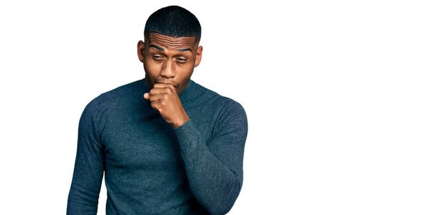 カジュアルなセーターを着た若い黒人男性は具合が悪く、風邪や気管支炎の症状として咳をした。ヘルスケアの概念.  - 写真・画像