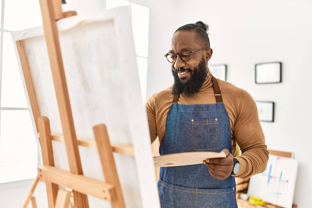 Nuori afrikkalainen amerikkalainen taiteilija mies hymyilee onnellinen piirustus art studio. - Valokuva, kuva