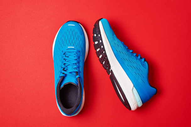 Coppia di sneakers running blu su sfondo rosso, vista dall'alto - Foto, immagini