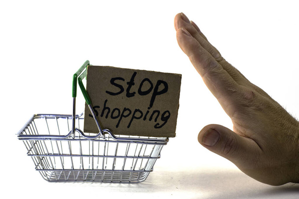Концепция отказа от покупки разумного потребления является жестко толкнул корзину с надписью прекратить покупки на белом фоне. Высокое качество фото - Фото, изображение