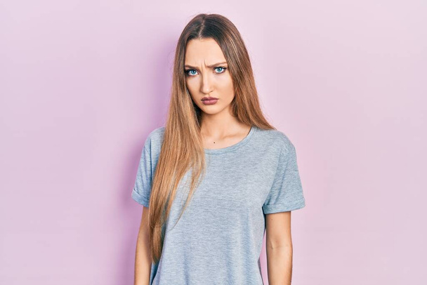 Young blonde girl wearing casual t shirt skeptic and nervous, frowning upset because of problem. negative person.  - Photo, Image