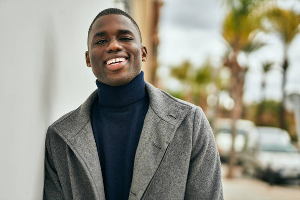 Giovane uomo afroamericano sorridente felice in piedi alla città - Foto, immagini