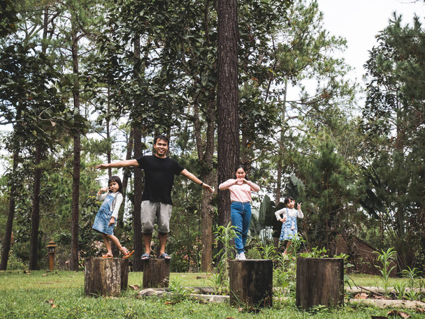 Onnellinen perhe seisoo puun luonnollisilla paikoilla metsäpalossa ja hymyilee kameralle. Perhe oli lomalla. Ekoturismin käsite. - Valokuva, kuva