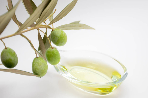 Свіжа стигла зелена гілка оливок в оливковій олії в скляній мисці
 - Фото, зображення