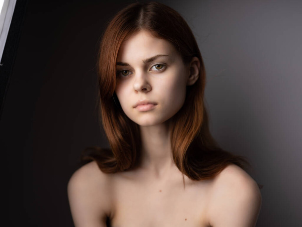 pretty woman red hair naked shoulders posing fashion dark background - Valokuva, kuva