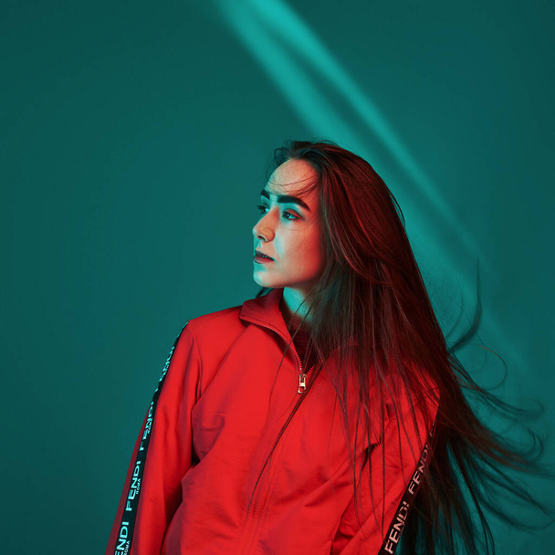 Standing in the neon lights. Studio shot indoors. Portrait of beautiful young girl. - Fotografie, Obrázek