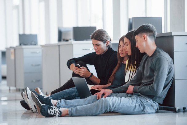 Modern technologies makes life easier. Group of young people in casual clothes working in the modern office. - Foto, imagen