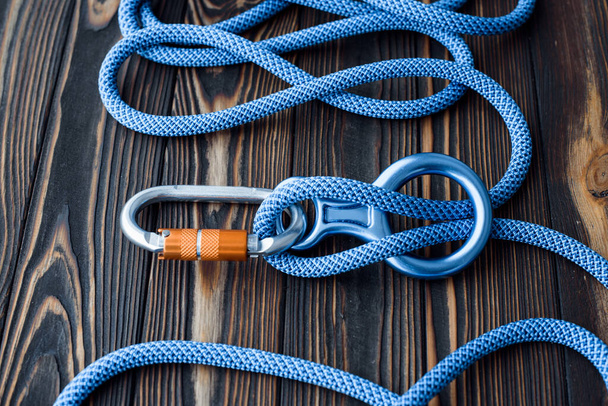 To the peak of the hill. Isolated photo of climbing equipment. Parts of carabiners lying on the wooden table. - Foto, immagini