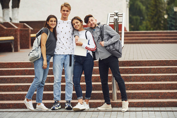 Posing for a camera. Group of young students in casual clothes near university at daytime. - Foto, immagini