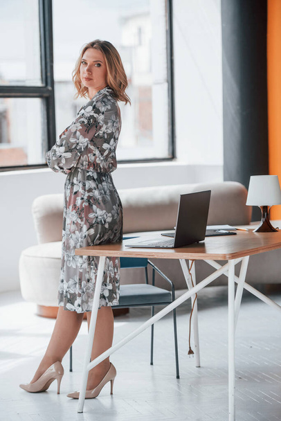 You must feel confident and strong to achieve best results. Businesswoman with curly blonde hair standing in room against window. - Foto, Imagen