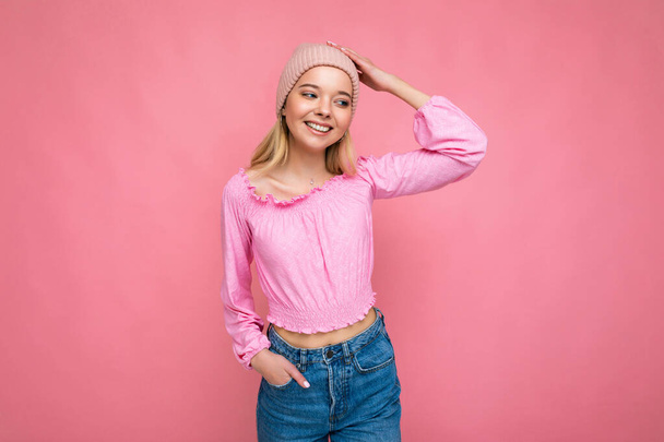 Bella positiva felice giovane donna bionda isolata su sfondo colorato parete indossando abiti casual elegante sensazione emozioni sincere guardando di lato - Foto, immagini